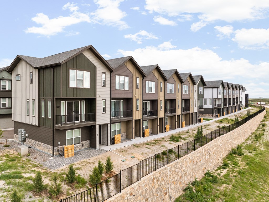 a row of townhomes in front of a retaining wall