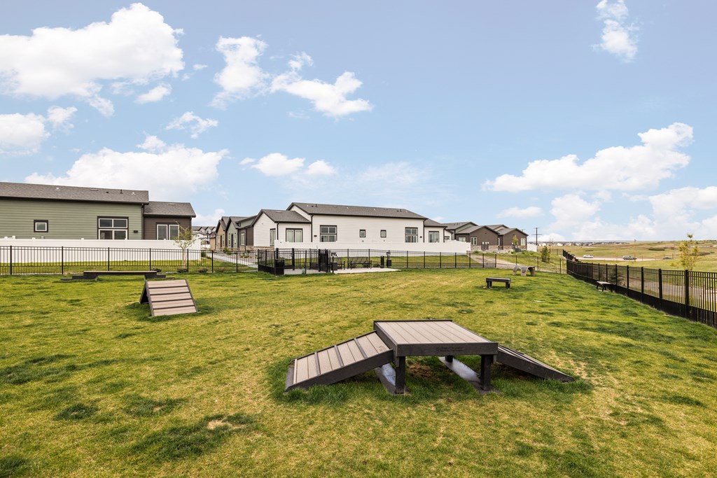 a park with benches and houses in the background