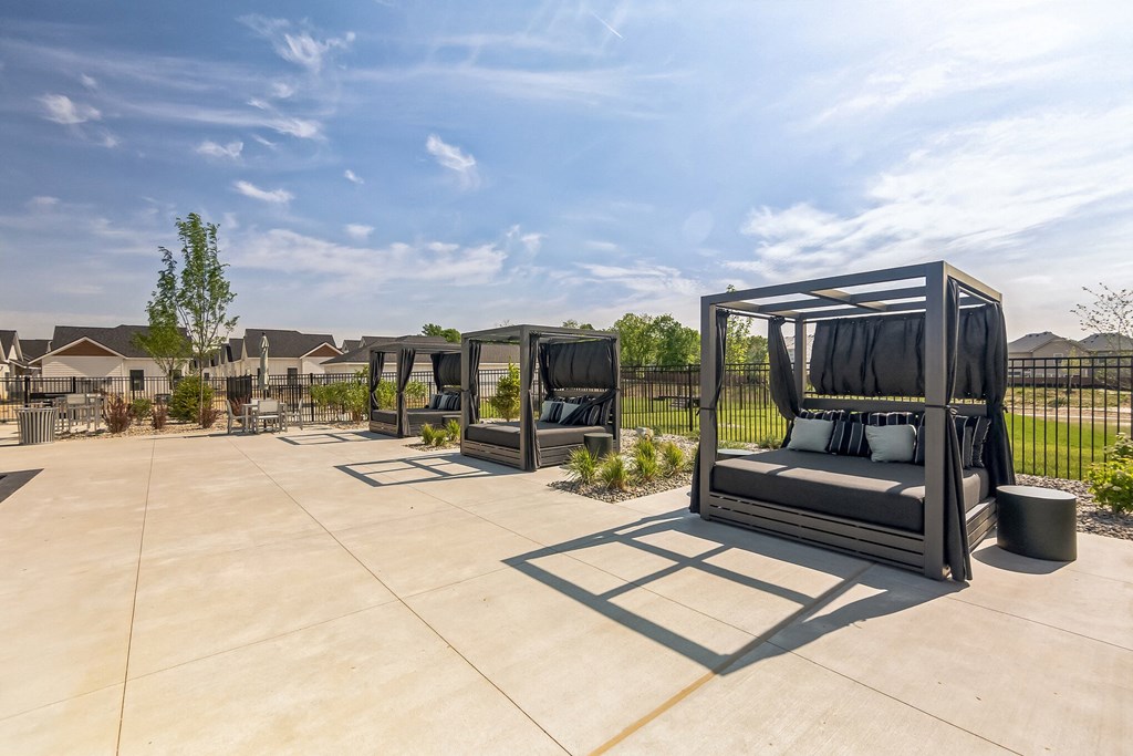 an outdoor lounge area at the whispering winds apartments in pearland, tx at Slate at Fishers District, Fishers, IN, 46037