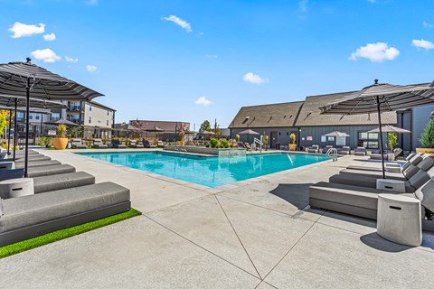 Resort style pool with lounge chairs and cabanas at The Logan Luxury Apartments, Idaho