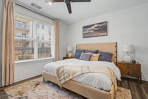 A bedroom with a large bed and a ceiling fan.
