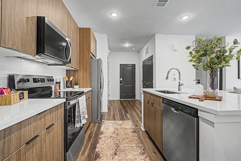 A modern kitchen with dark wood cabinets and stainless steel appliances.