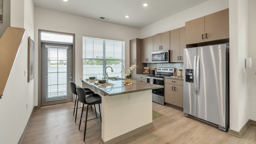 a kitchen with a large island and stainless steel appliances at Slate at Fishers District, Fishers