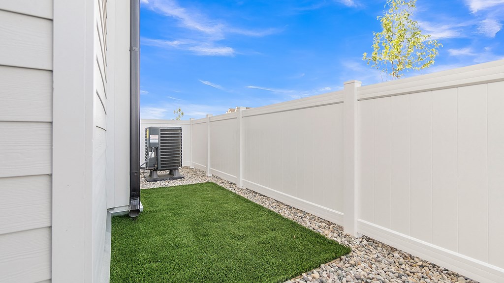 a white fence with a small patch of grass in front of it at Slate at Fishers District, Fishers, IN, 46037