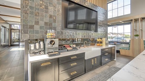 a kitchen with a large counter and a large tv on the wall at Slate at Fishers District, Indiana