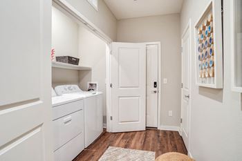 a laundry room with a washer and dryer and a white door at Watermark at Urban Blu, Florida, 32407