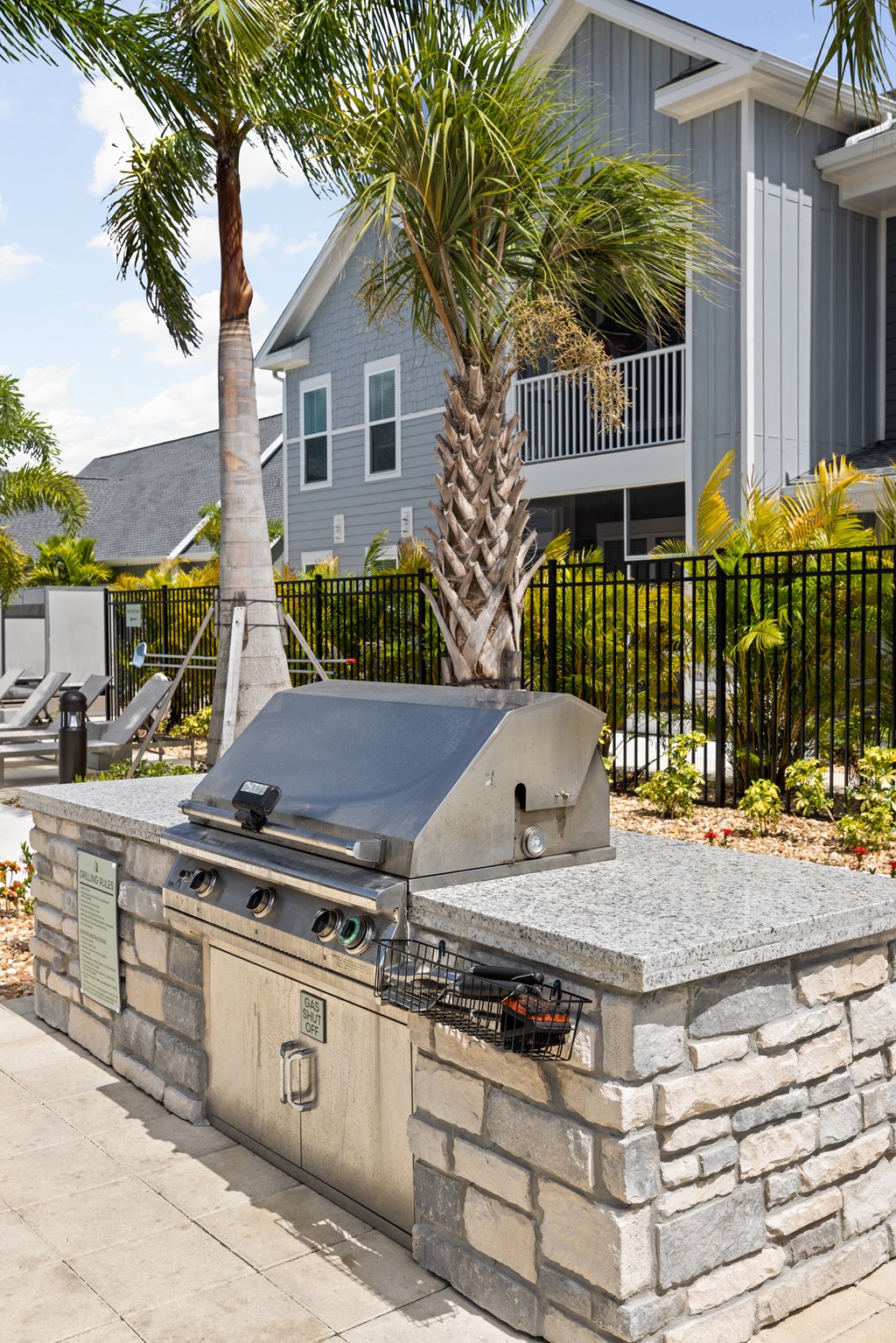 a stone barbecue grill in front of a house at Palm Grove in Ellenton, FL 34222