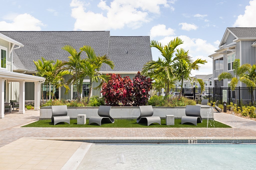a yard with a pool and furniture in front of a house at Palm Grove in Ellenton, FL 34222