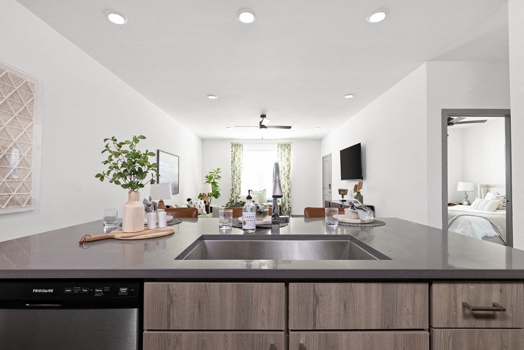 a modern kitchen with a large sink and a living room in the background at Palm Grove in Ellenton, FL 34222