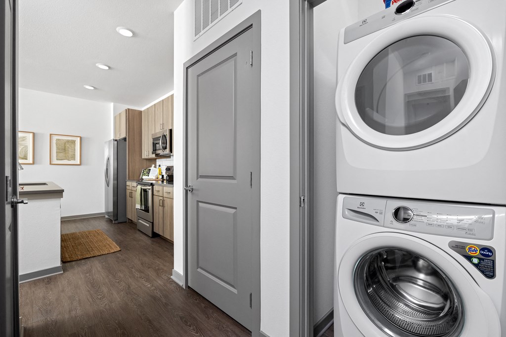 a white washer and dryer in a white laundry room with a white door at Palm Grove in Ellenton, FL 34222