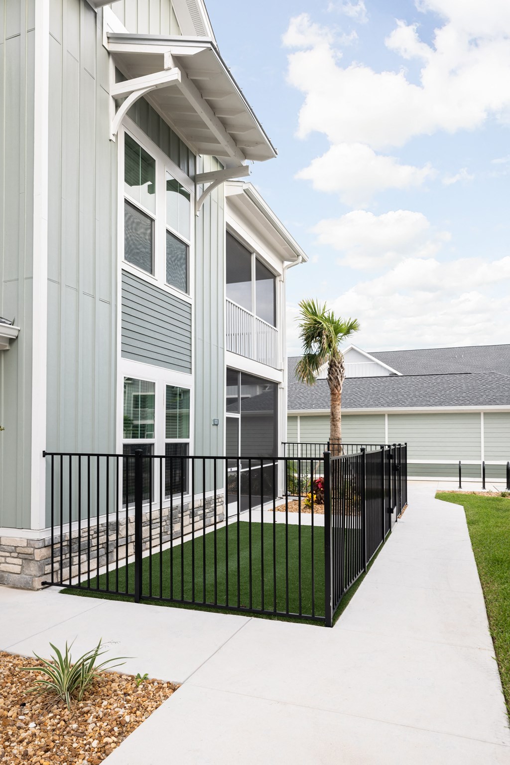 a house with a sidewalk and a palm tree in front of it at Palm Grove in Ellenton, FL 34222
