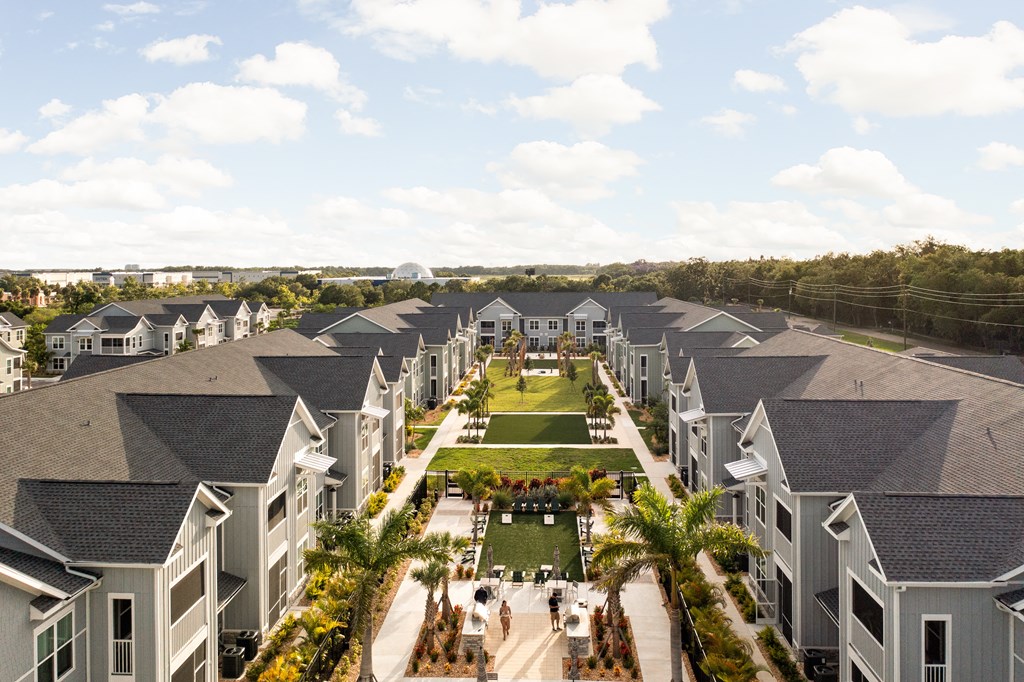 an aerial view of a row of houses with a grassy area and palm trees at Palm Grove in Ellenton, FL 34222