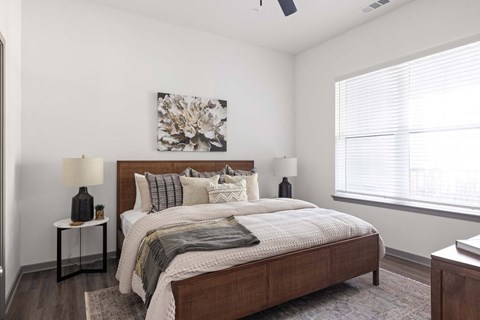 A bedroom with a large bed and a painting on the wall.