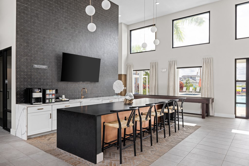 a large kitchen with a large island with chairs and a tv at The Sophia, Venice, FL, 34275