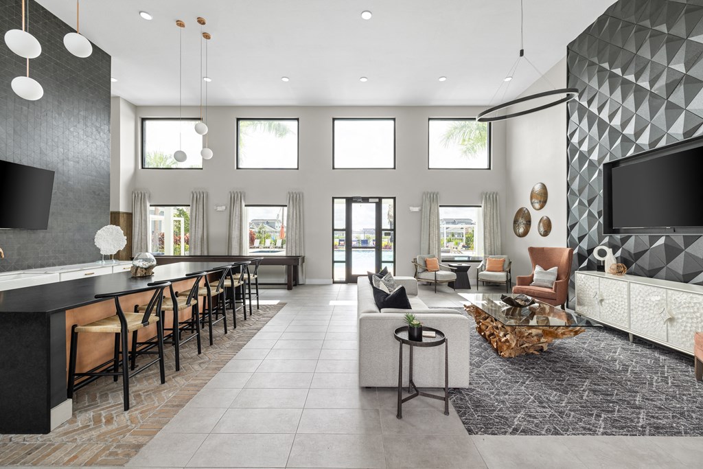 a large living room with a large tv and a table with chairs at The Sophia, Venice, FL, 34275