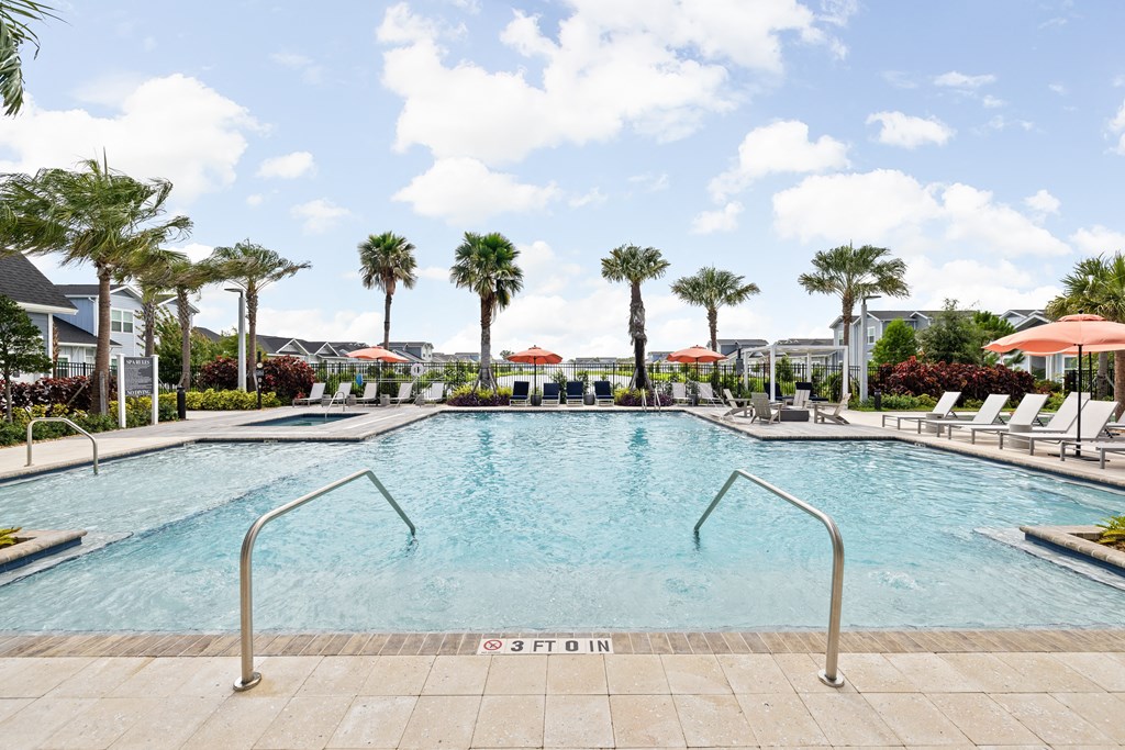 a large pool with chairs and palm trees at The Sophia, Venice, FL, 34275