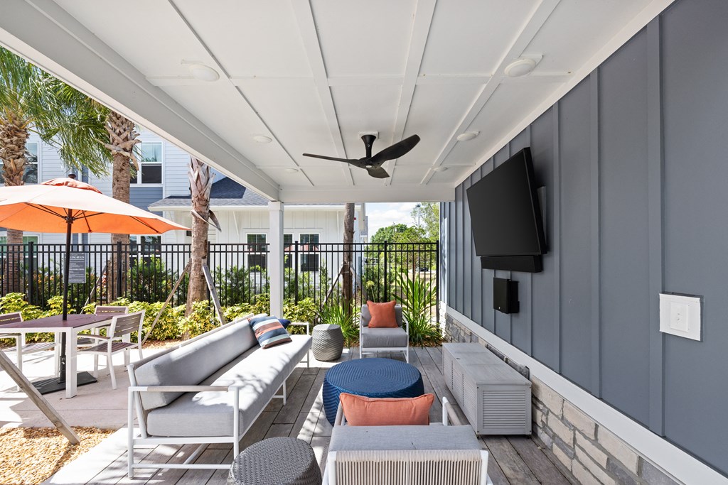 a patio with couches and chairs and a tv on the wall at The Sophia, Venice, FL, 34275