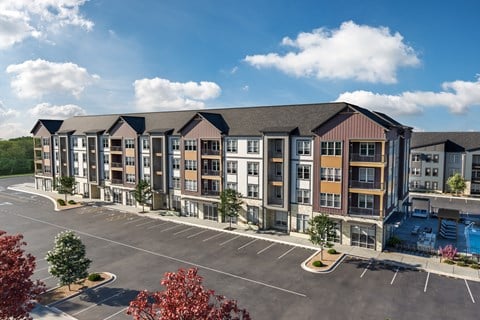 a rendering of an apartment complex in a parking lot