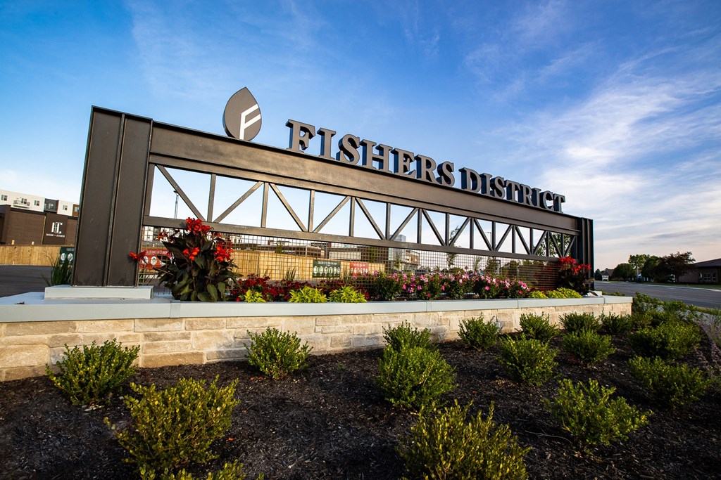 a sign for fishers district with plants in front of it at Slate at Fishers District, Fishers, IN, 46037