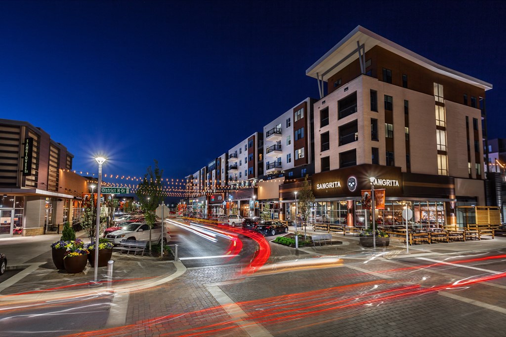 a city street at night with cars and buildings at Slate at Fishers District, Fishers, IN
