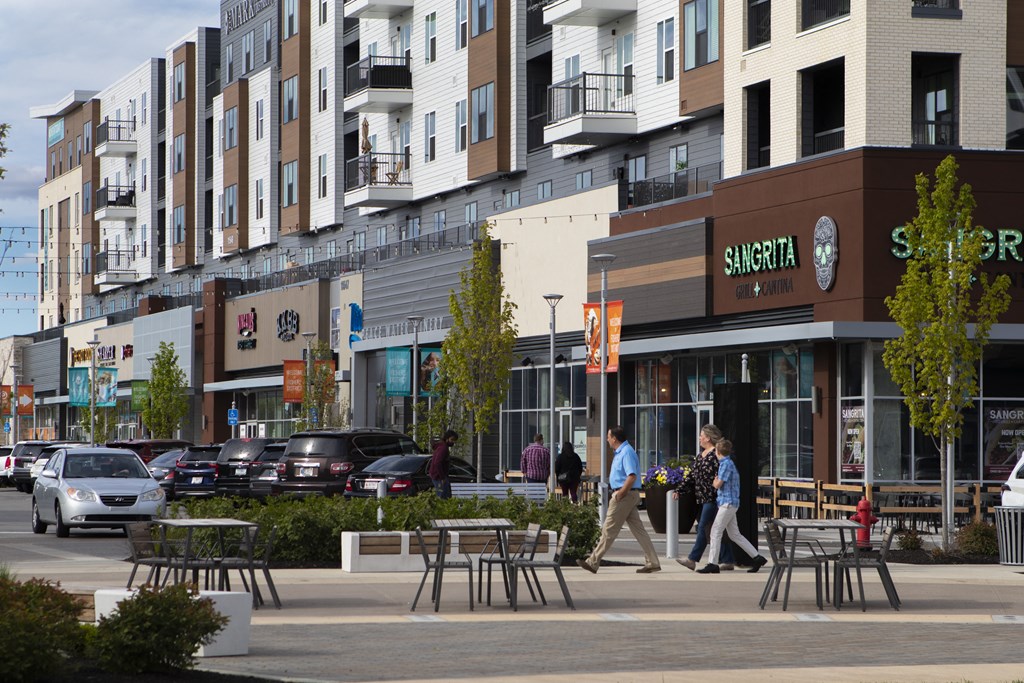 people walking down a street in front of buildings at Slate at Fishers District, Indiana, 46037