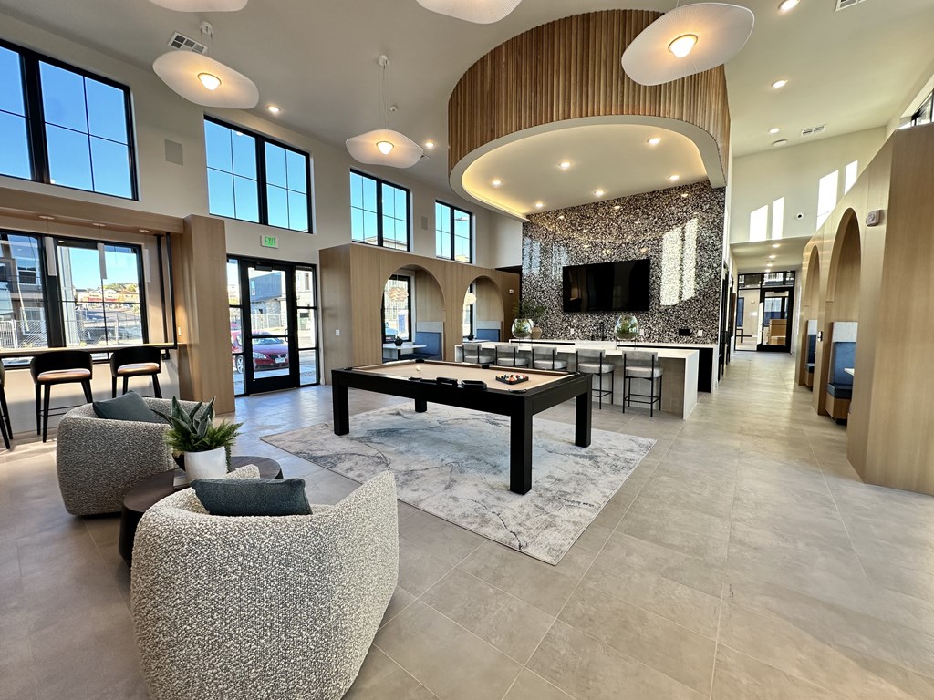 A spacious living room with a large TV and a stone fireplace.
