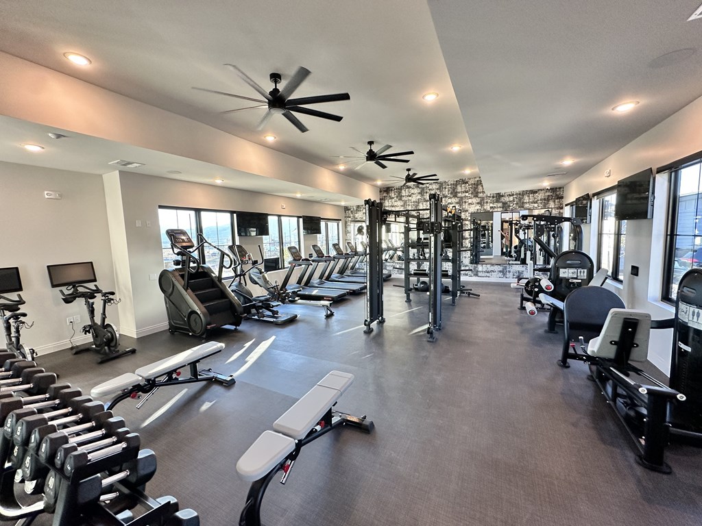 A spacious gym with a variety of equipment including treadmills, weights, and exercise machines.