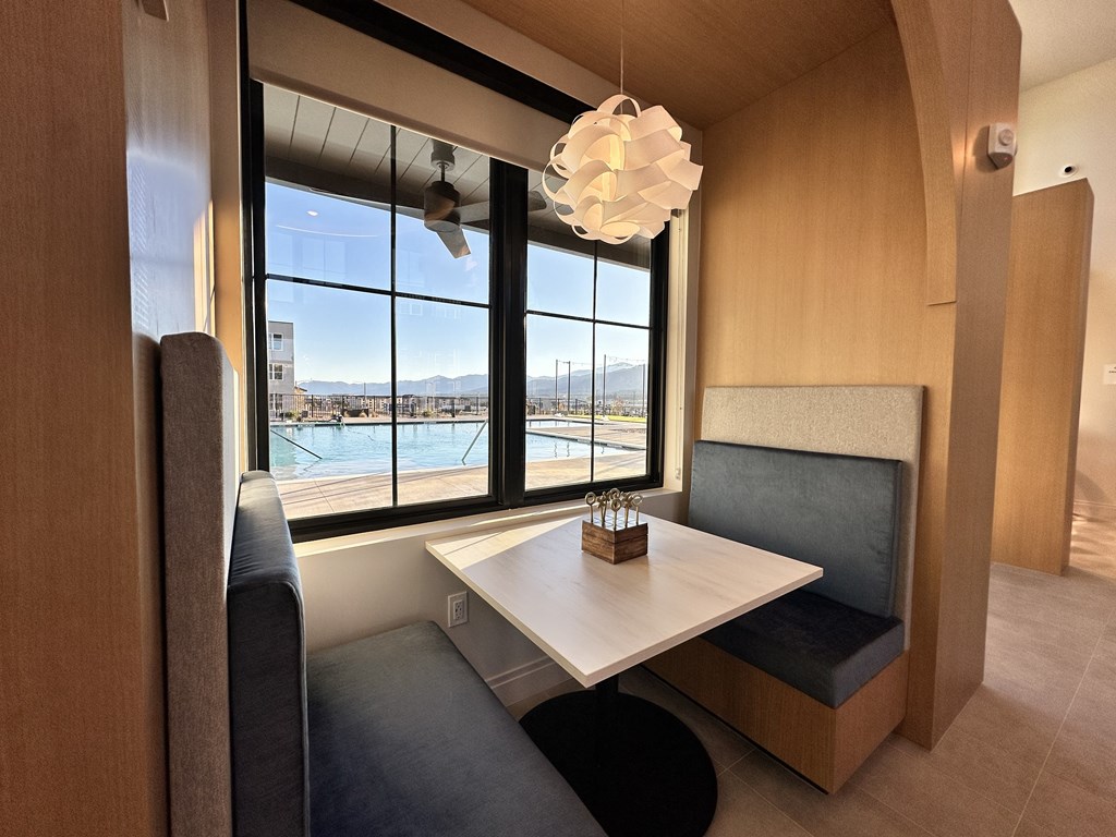 A modern dining area with a table and chairs and a view of the outside.