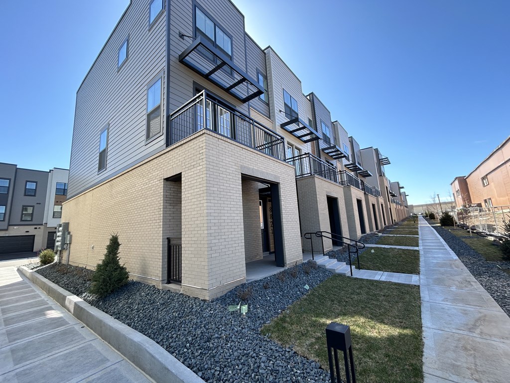 a row of apartments with balconies on the side of a sidewalk at Meridian at CityPlace, Woodbury, MN 55125 