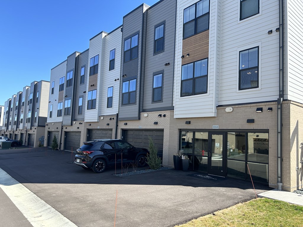 an apartment building with a car parked in front of it at Meridian at CityPlace, Woodbury