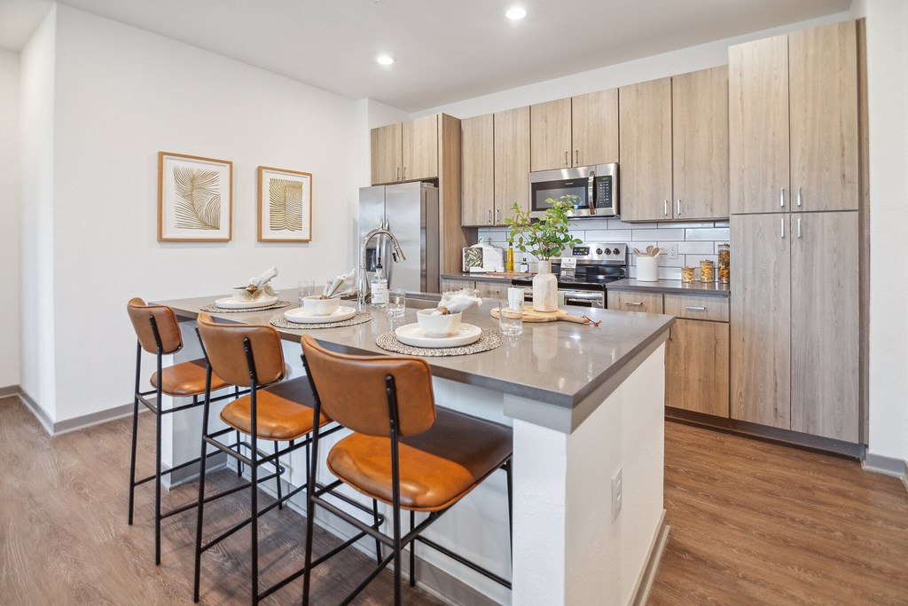 a kitchen with a large island with stools and a table with chairs  at Palm Grove, Ellenton