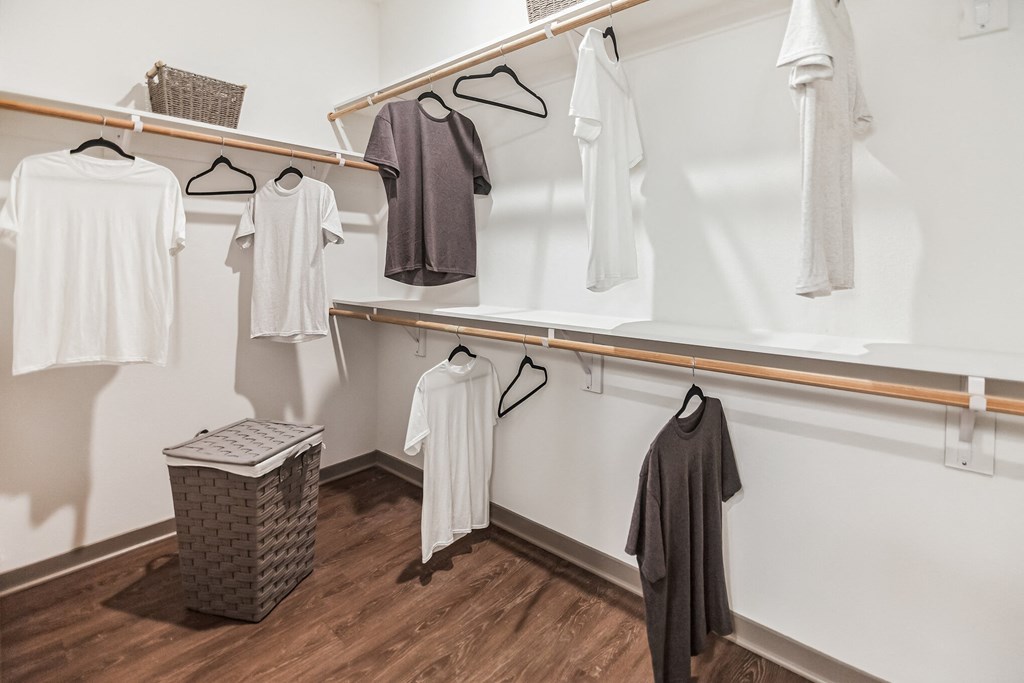 a walk in closet with white clothes and a wood floor  at Palm Grove, Ellenton, FL