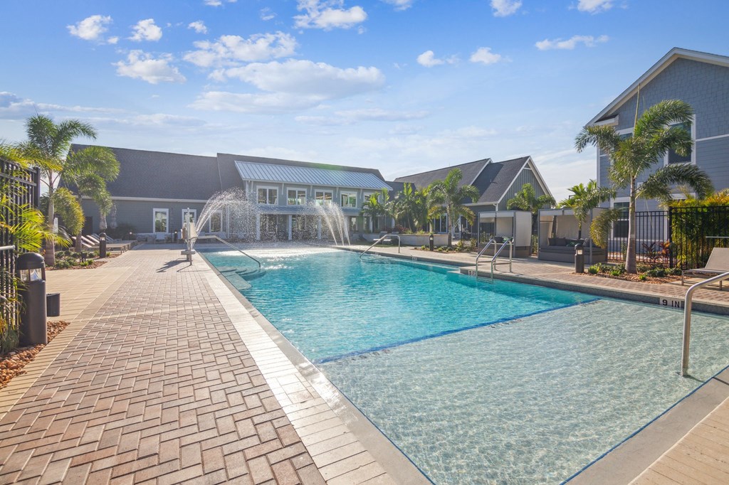 a swimming pool with a fountain in front of a house  at Palm Grove, Ellenton, Florida