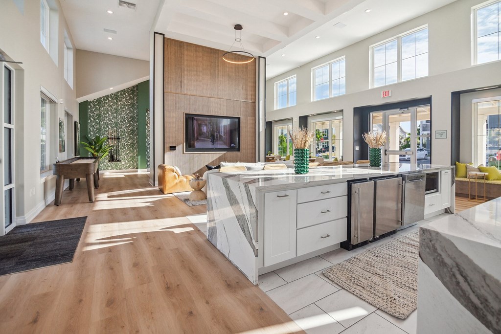a kitchen with a large island and a living room with a tv  at Palm Grove, Ellenton, FL