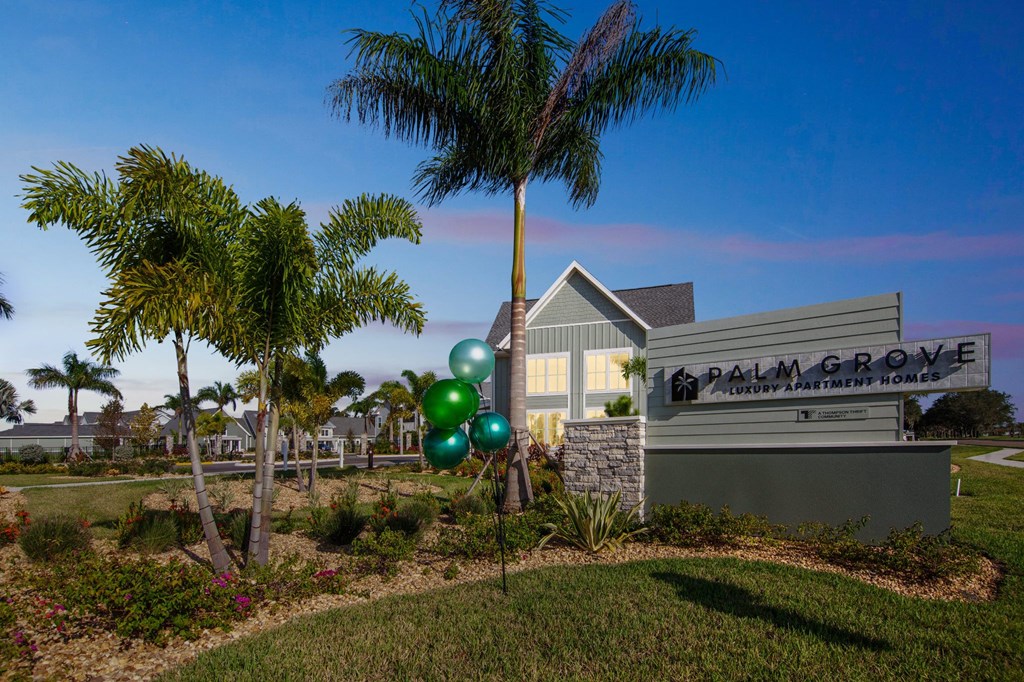 a building with palm trees and balloons in front of it  at Palm Grove, Ellenton