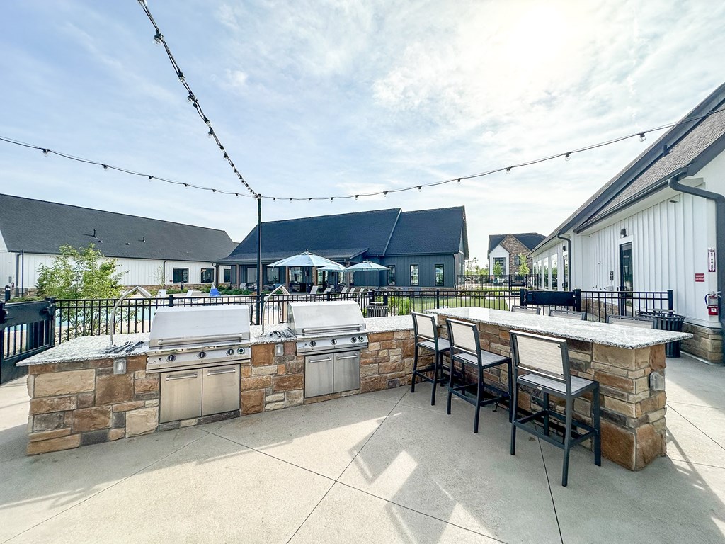 spacious outdoor patio with grill and bar and seating at The BLVD at Wilson Crossings, Wyoming, MI
