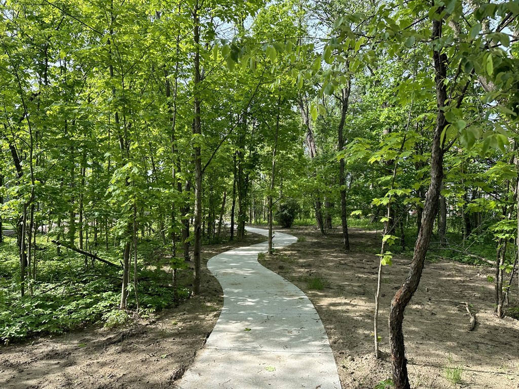 a path in the middle of a forest at The BLVD at Wilson Crossings, Wyoming, MI 49418