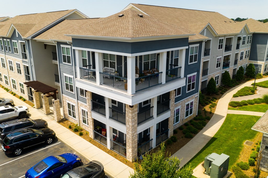 an aerial view of an apartment building with cars parked in a parking lot