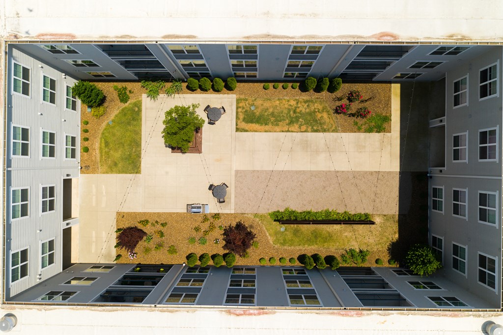 an aerial view of a parking lot in front of an apartment building