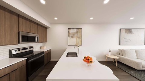 A modern kitchen with a white island and a white sofa in the background.