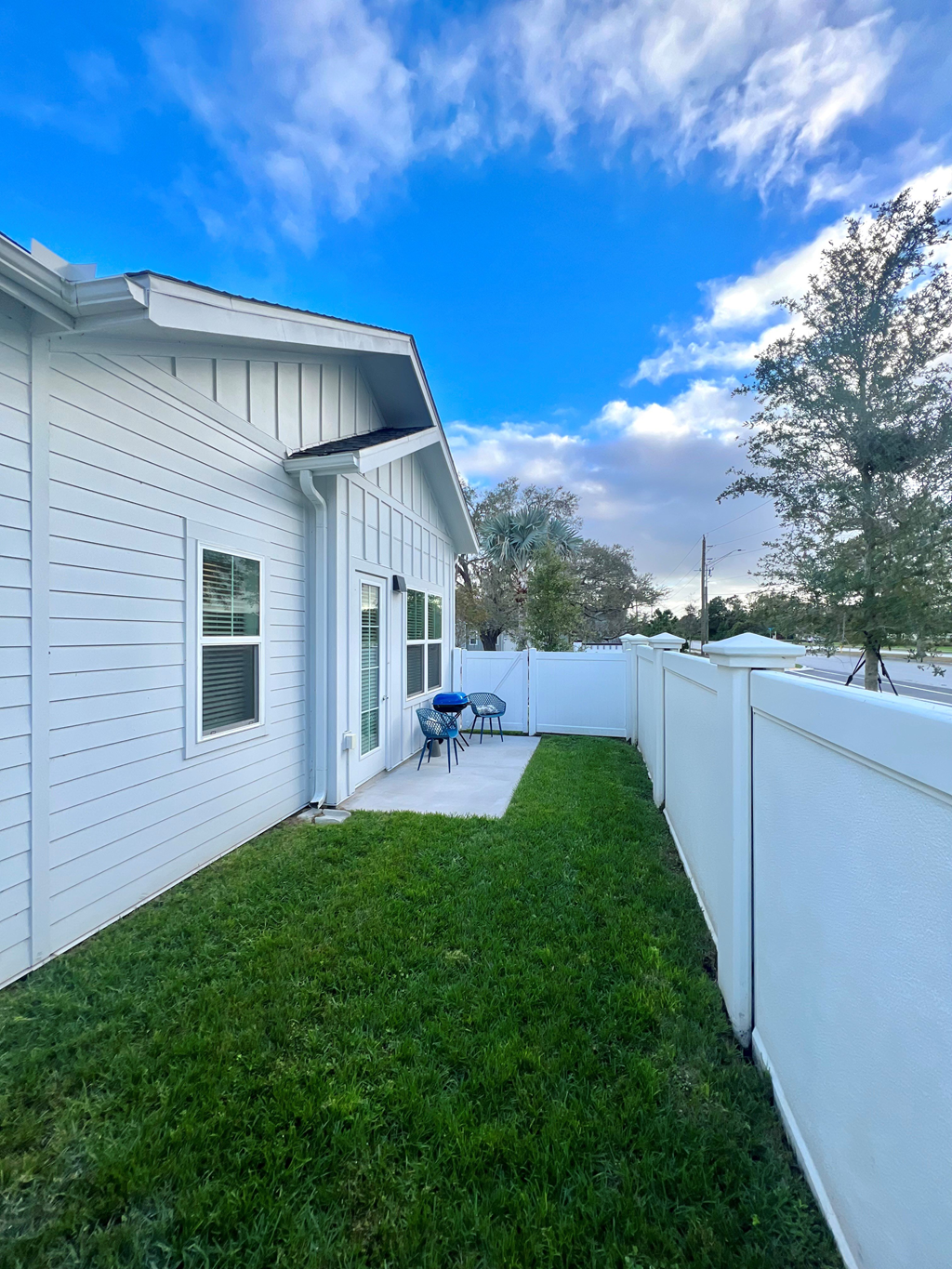 a backyard with a fence and a patio with a table and chairs at The Sophia, Venice, FL, 34275