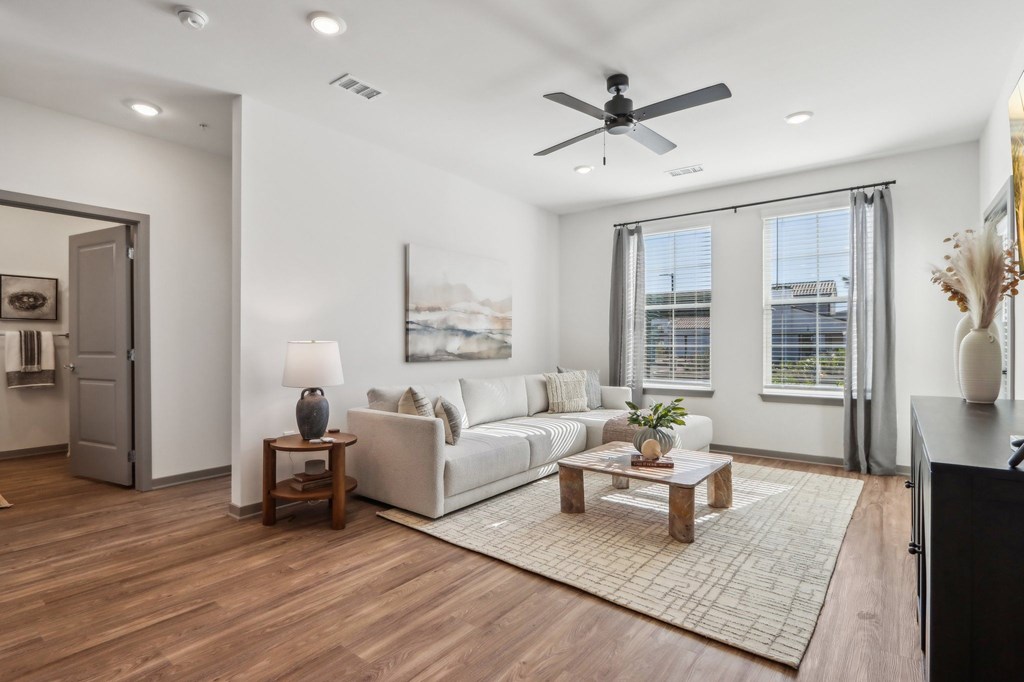 a living room with a couch and a ceiling fan  at Stella Luxury Apartment Homes, San Tan Valley, AZ