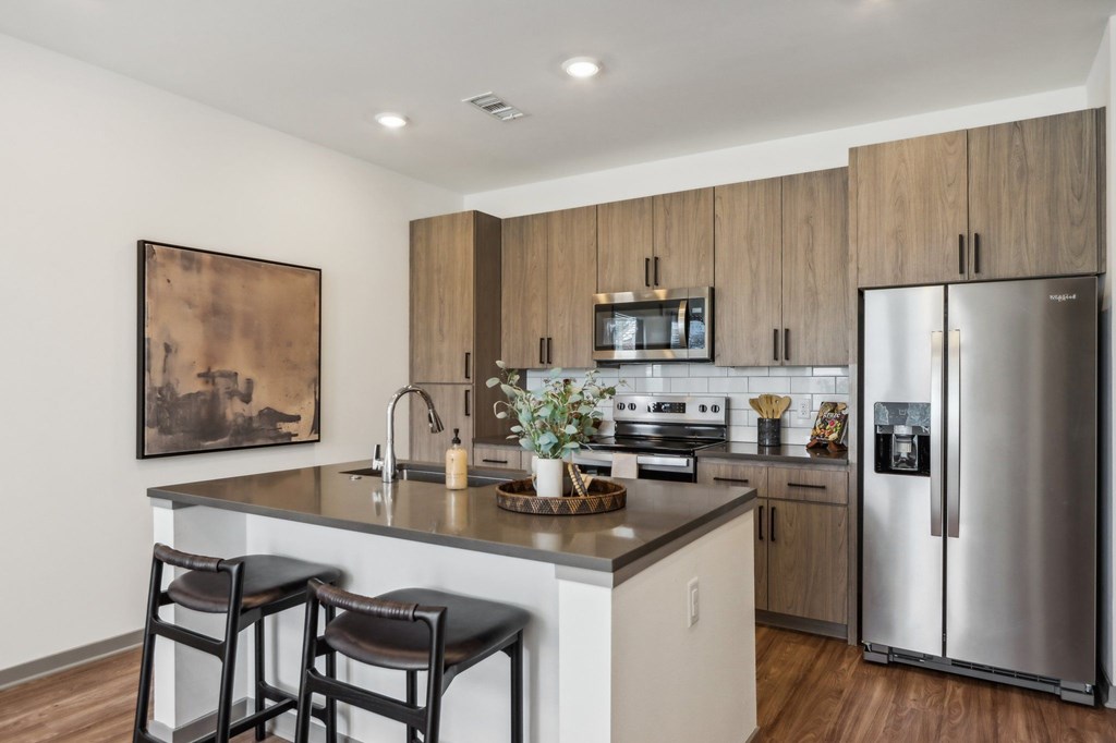 a kitchen with stainless steel appliances and a island with two chairs a kitchen with stainless steel appliances and a island with two chairs at Stella, San Tan Valley Arizona