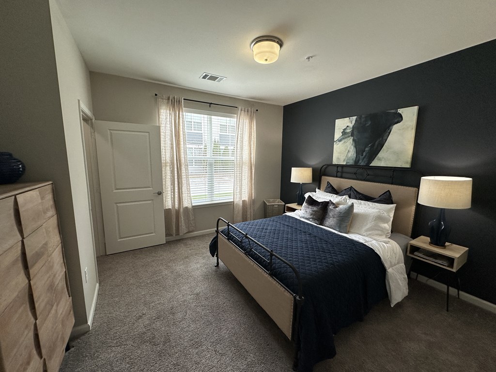 a master bedroom with a large bed and a black accent wall at Watermark at Steele Crossing, Fayetteville, Arkansas