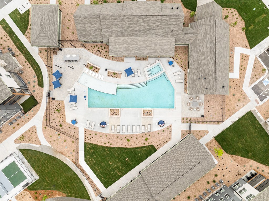 an aerial view of a swimming pool in a suburb of a city