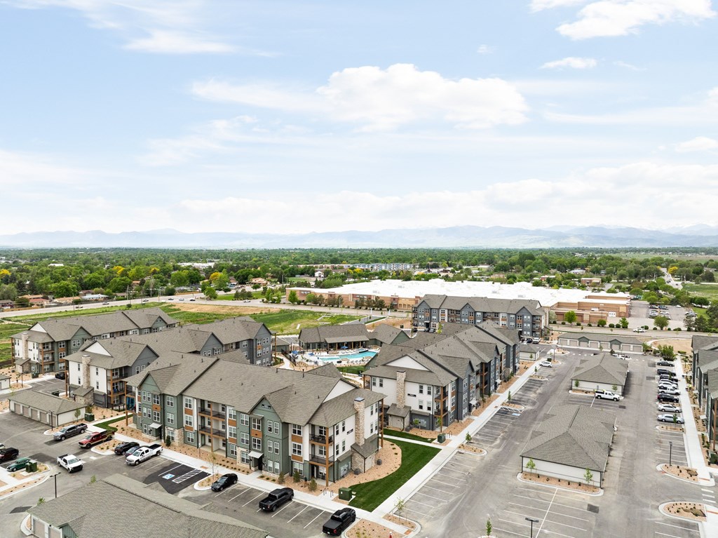 an aerial view of an apartment community with cars parked on the street