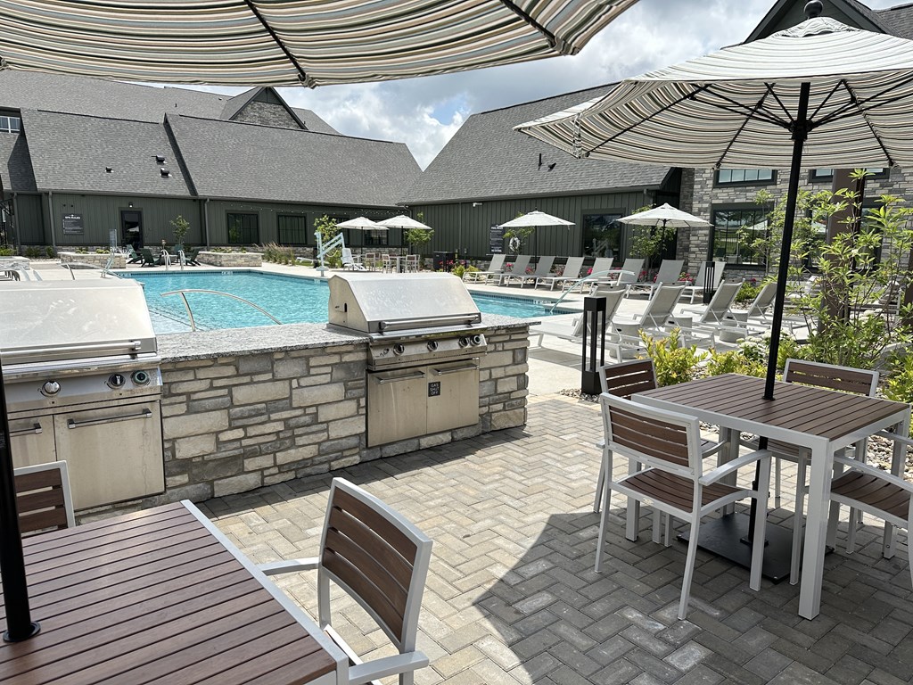 a patio with a pool and tables with umbrellas