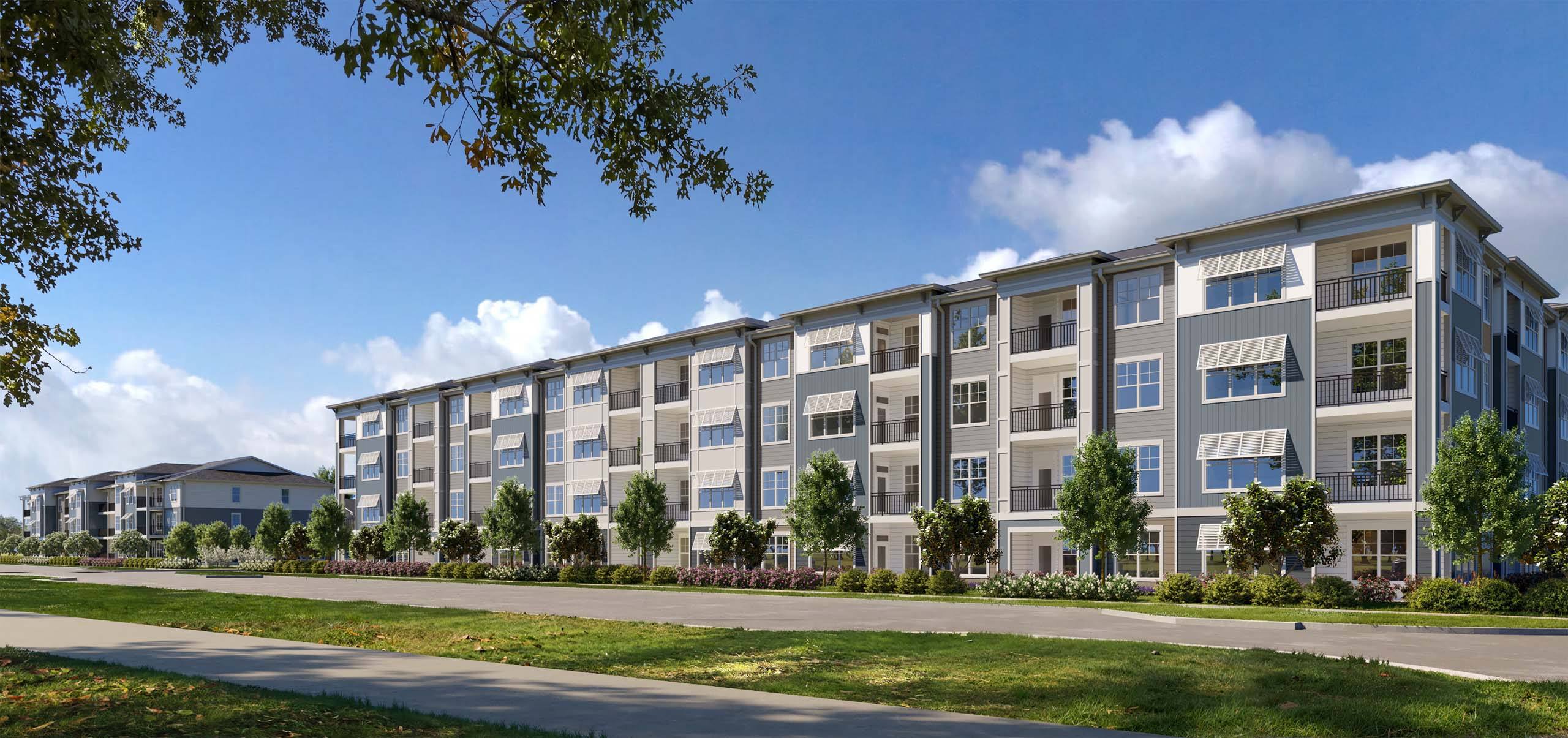 A large, modern apartment building with a grassy area in front.