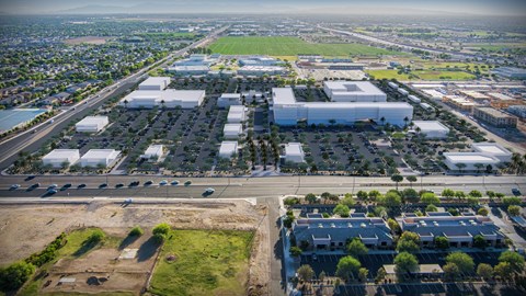 An aerial view of a large industrial area with multiple buildings and a parking lot. at The Residences at The Gilmore in Gilbert, AZ