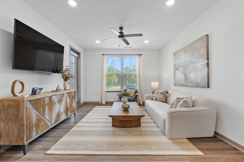 A living room with a television, a couch, and a coffee table.